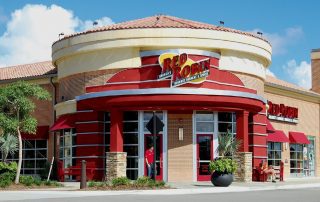 Red Robin Gourmet Burgers & Spirits restaurant with red rotunda entrance and tile roof at Gulf Coast Town Center