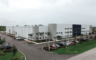 Aerial view of Safa Goods Distribution Center, a large white two-story warehouse with palm-lined parking lots